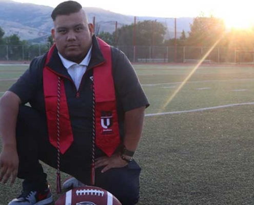 SOU Graduate Spotlight Jose Angel Stephen-Herman kneeling on football field at Southern Oregon University Learn More